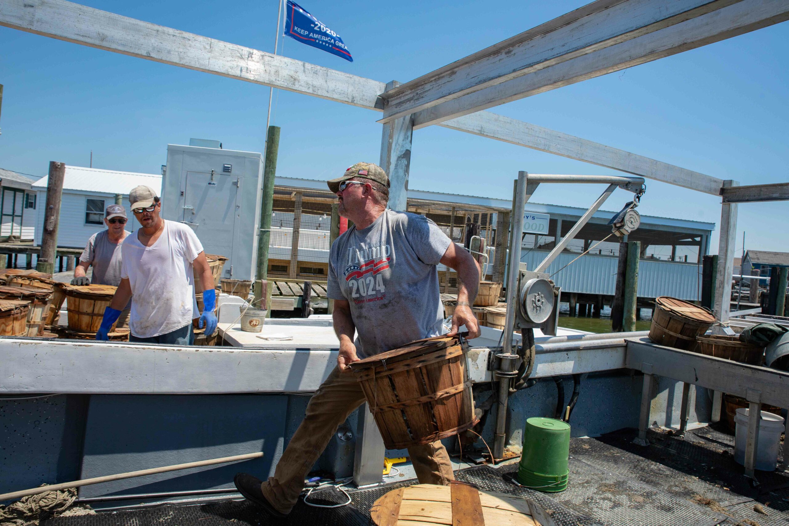 Tommy Eskridge offloading crab bushels to another boat | VPM COM